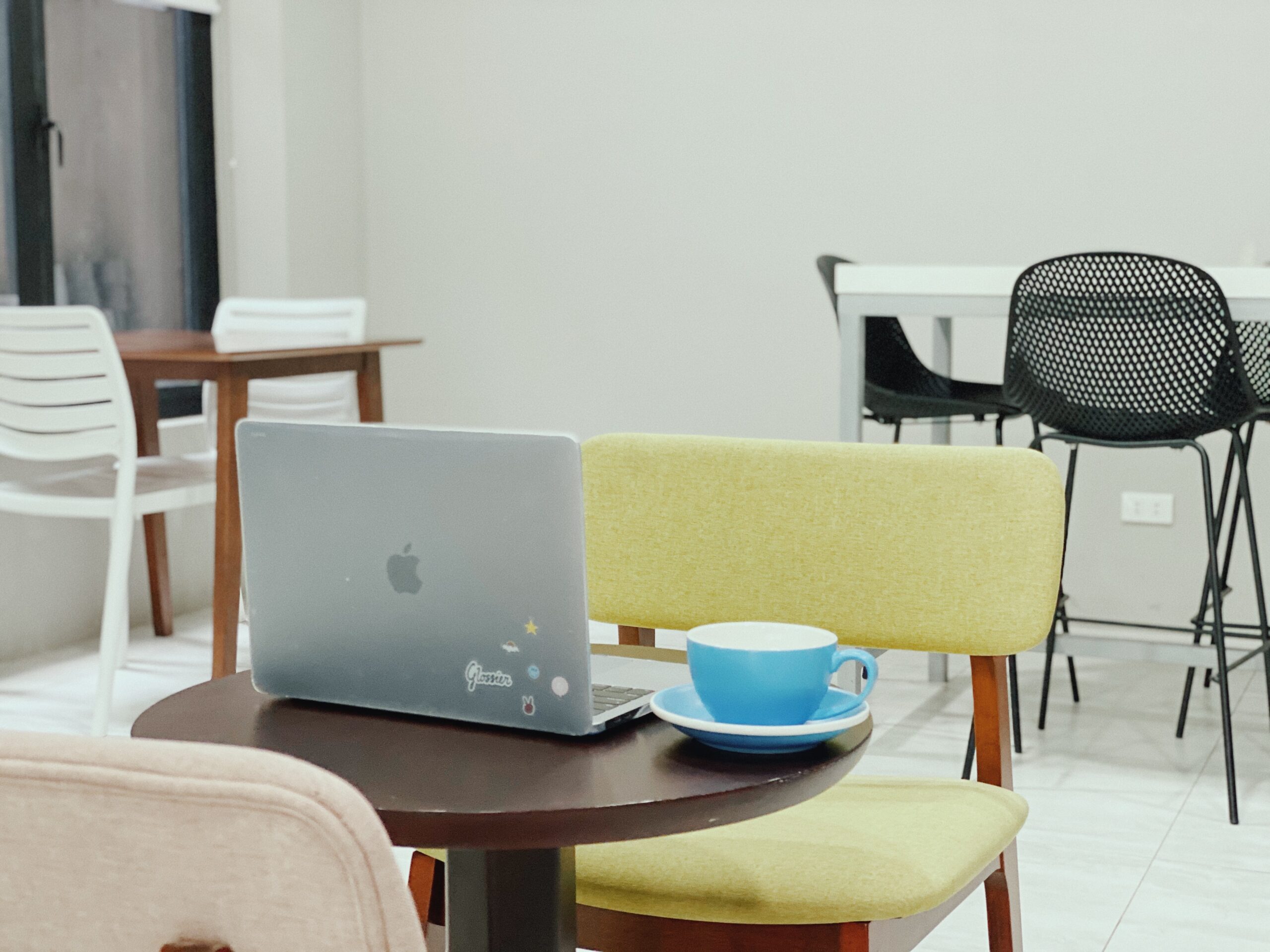 a laptop and a cup in a coworking space